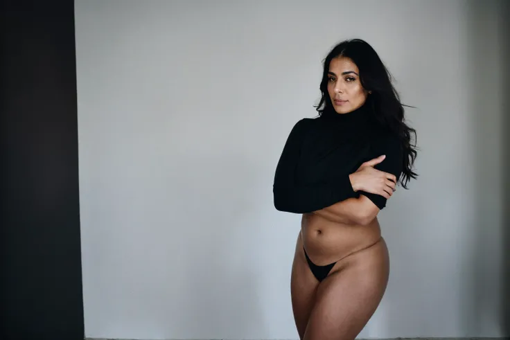 RAW photo,dark,moody,35mm focal lenght,underexposed,cold,candid photograph,artistic perspective,full body,photo of a beautiful,influencer,45yo Kurdish woman,black hijab, detailed skin,naked, looking away from viewer, thick body structure,grey background,no...