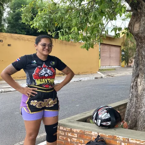 a woman that is standing next to a tree, by Nándor Katona, instagram, toyism, heroic muay thai stance pose, cycling!!, wearing knee pads, carnaval de barranquilla, wearing a tee shirt and combats, 2022, foto realista, posing for a picture