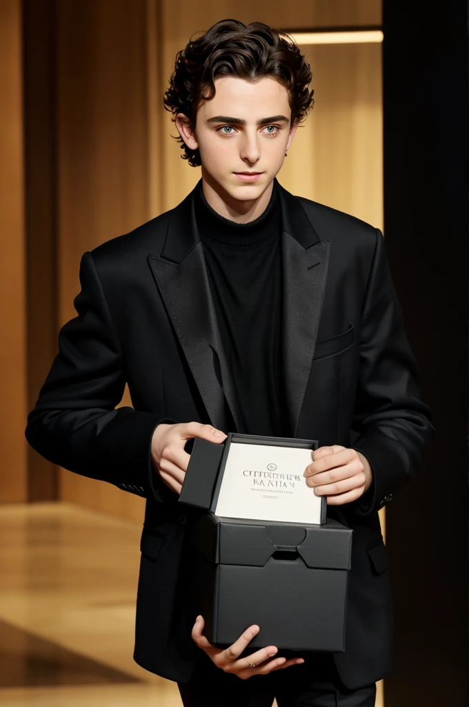 Timothée Chalamet holding a medium rectangular black box in his hands