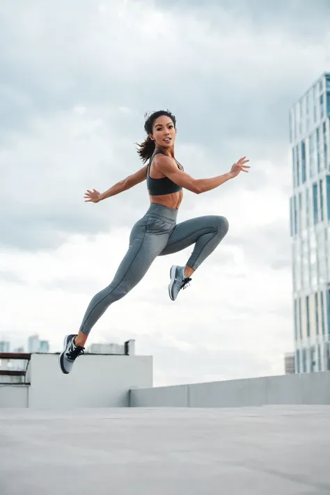 arafed woman in a sports bra top and leggings jumping in the air, leaping into the air, leaping, jump pose, leaping with arms up, standing on rooftop, leaping towards viewer, athletic fashion photography, dynamic active running pose, in a jumping float pos...