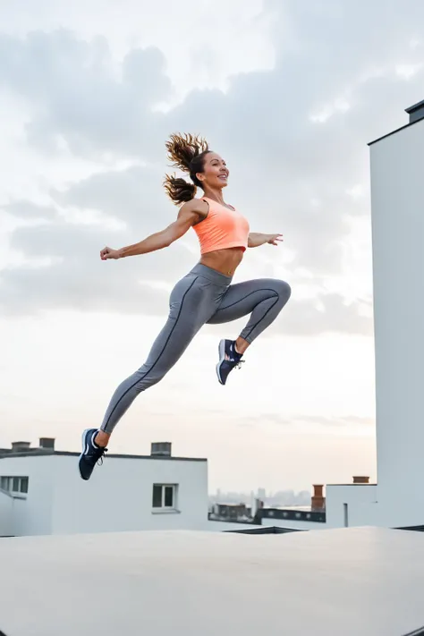 arafed woman in a sports t shirt and leggings jumping in the air, leaping into the air, leaping, jump pose, leaping with arms up...