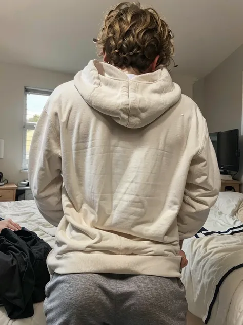  19 year old boy with a Curly medium dirty blonde hair, wearing a white hoodie with black athletic pants , inside the bedroom , freckles, back view 