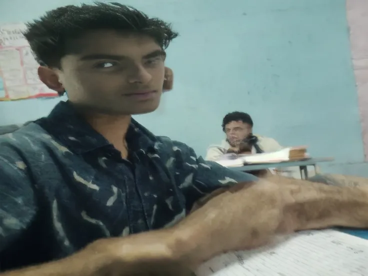 there is a handsome body of 17 years old sitting at a desk with a mathematics book, in a classroom, blurry image, setting in class, student, in a school classroom, at class, candid picture, sitting in the classroom, ayan nag, very very low quality picture,...