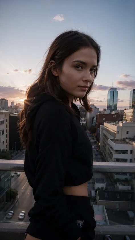 young woman looking at the camera, black sweatshirt, city, bright sunset