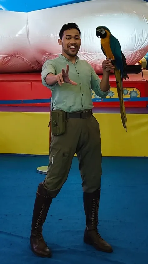 30 years old male  wearing sage shirt, and green army tactical trousers holding blue and gold macaw on his hand, clear white background