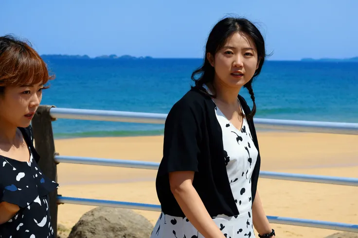 A woman in a black and white dress is walking on the beach, next to her is a woman in a black and white dress., Standing on the beach, Nanae Kawahara, Standing near the beach, at the beach, Chiho Aoshima, Against the backdrop of the sea, junko enoshima, at...