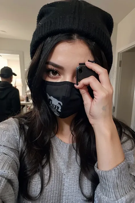 Sexy girl with long black hair taking a selfie in a black mask, a gray sweater and a black hat covering his face with his hand 