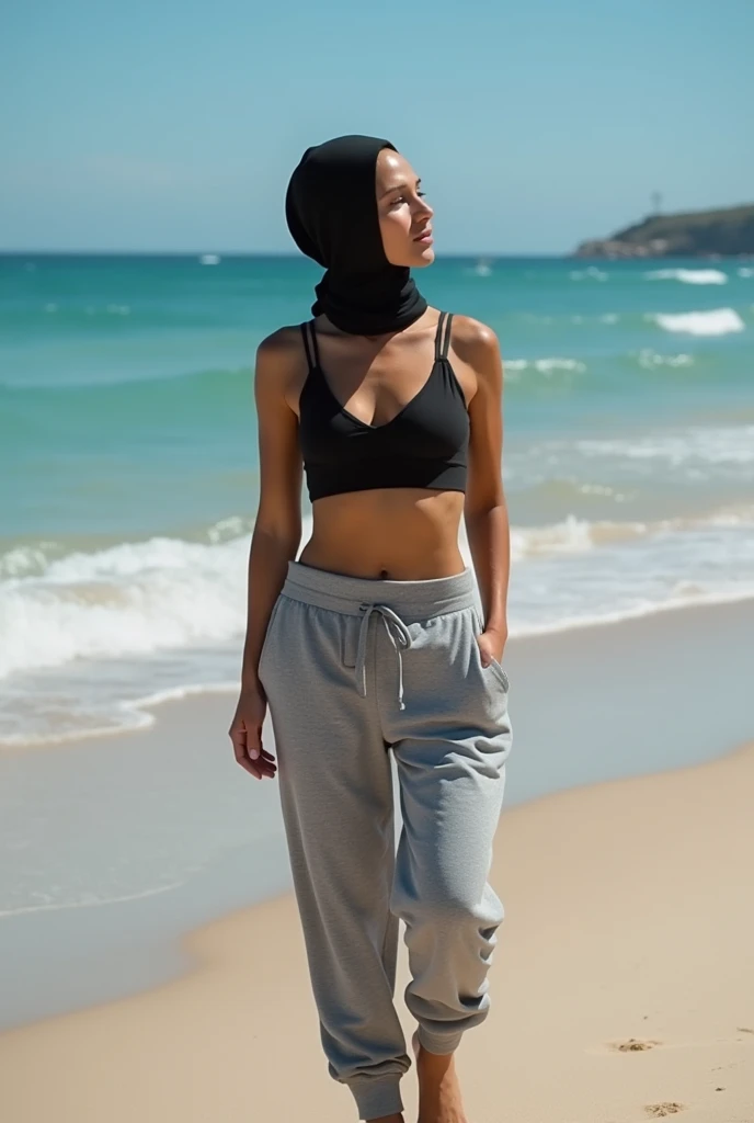 with black headscarf, grey sweatpants, barefoot woman without bra, sunbathing on the beach