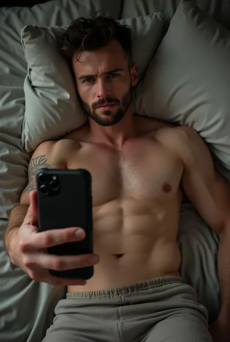 Naked lower waist body of muscular man lying on bed selfie from phone screen