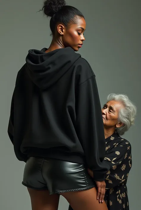 black woman hair in a bun black hoodie   black leather short shorts   a old grandma in a dress on her knees kissing her ass behind her


       