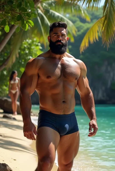 Strong muscular hairy bearded Puerto Rican man in navy blue underwear on the beach, standing, enjoying the sun and the beach on the banks of a lagoon surrounded by greenery, being spied on by a woman in the background.