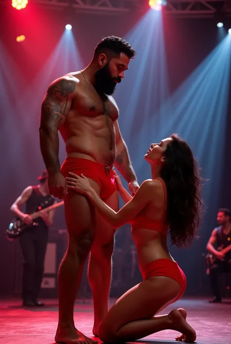 A young Puerto Rican man with a beard, hairy, strong and muscular, in red underwear, having her thighs touched and smoothed by a beautiful woman in red panties crouching in front of her, in performance on a stage of a television program presented by a famo...