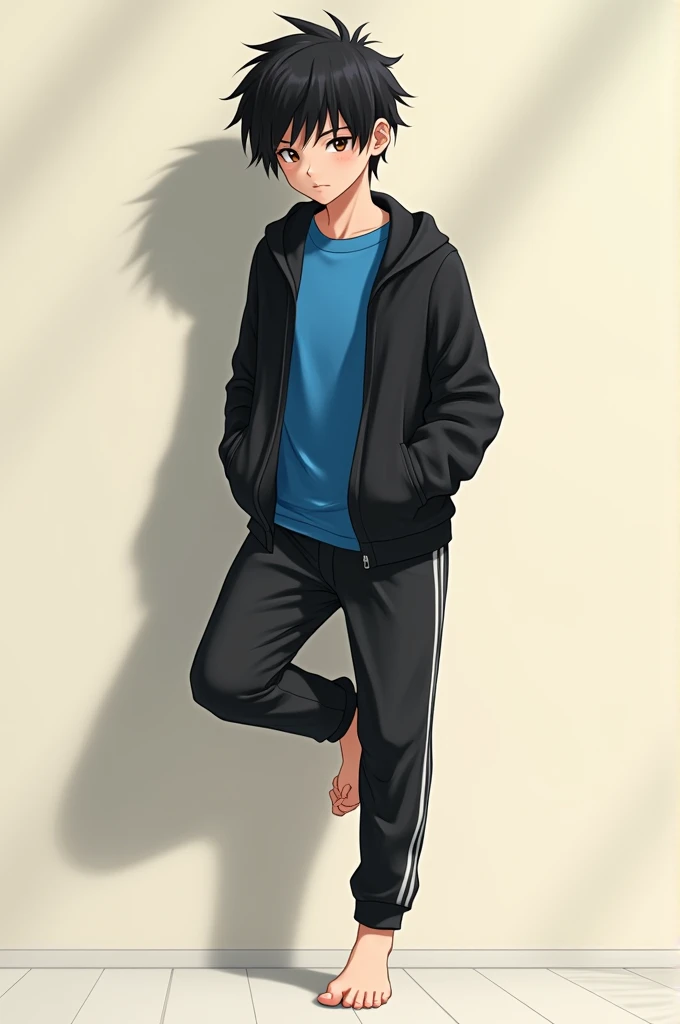 Black haired boy barefoot in black sports pants, black open top sweater and under the sweater he has a blue shirt leaning against the wall lifting his foot