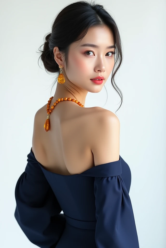 Beautiful Asian woman wearing modern dark blue dress with open shoulders. Three quarter portrait on white background. Straight posture. She wears beauty amber earrings and amber beads