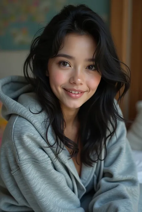 A woman with long black hair, wearing a gray hoodie and long sweatpants, smiling beautifully.