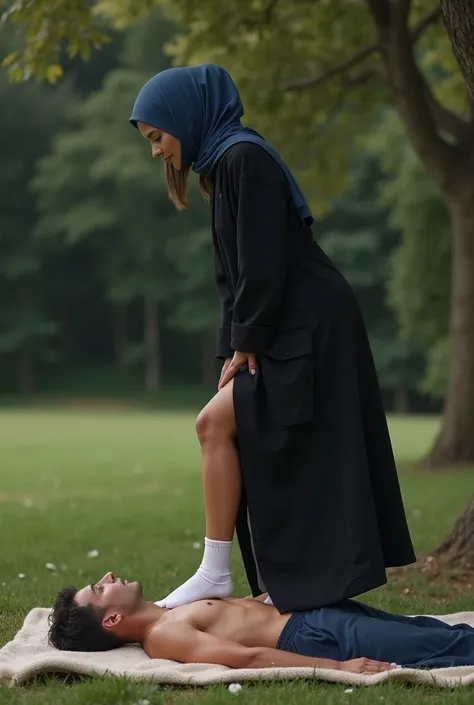 Navy blue headscarf at the picnic, Black long coat, white socks,Sexy skinny woman covered all over. Man lying in front of woman. Woman puts her foot on the front of man&#39;s sweatpants. 