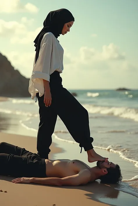 Black headscarf on the beach,black sweatpants,barefoot sexy skinny woman in white long sleeve t-shirt. Man lying in front of woman. Woman puts her foot on the front of man&#39;s sweatpants. 