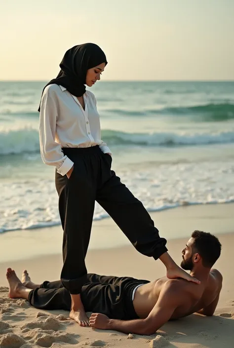 Black headscarf on the beach,black sweatpants,barefoot sexy skinny woman in white long sleeve t-shirt. Man lying in front of woman. Woman puts her foot on the front of man&#39;s sweatpants. 