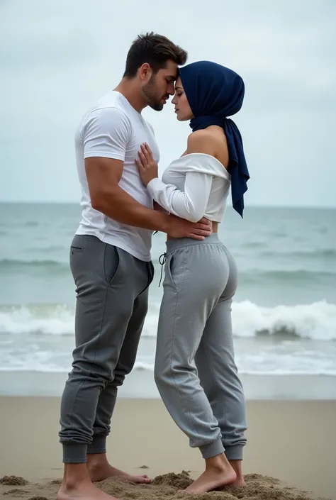 Navy blue headscarf on the beach, grey baggy sweatpants, white long sleeve t shirt, barefoot, Sexy skinny woman bent over. Gym instructor hugs woman from behind. 