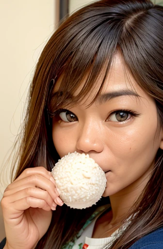 woman looking at camera holding rice ball close to her mouth