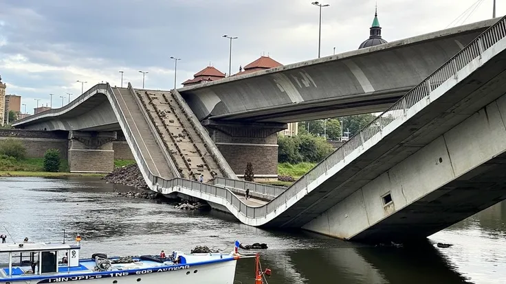 A supernaturally large fat black naked woman stands on a collapsed bridge, debris lies around them. She looks sad. Famous Dresden buildings can be seen in the background. A river runs under the bridge.