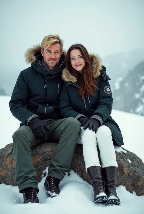 Man in black parka, military pants, blonde hair green eyes, a woman in a black parka, white pants, brown hair and light brown eyes sitting on a rock in the snow smiling 