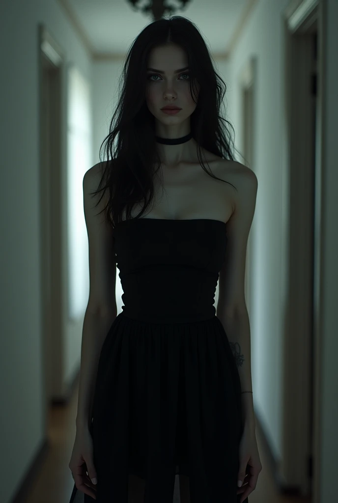 White skin woman long black hair, long strapless black dress in a dark hallway with a white wall 