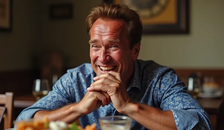 Create a high-resolution image of Arnold Schwarzenegger sitting at a dining table, wearing a blue printed shirt. His facial expression should show him chuckling or laughing lightly, as if he’s amused by something. He should have both hands placed on his fa...