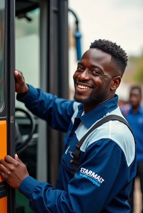 Black man smiling with blue and white color Starmalt logo on shirt fixing a bus while people watch