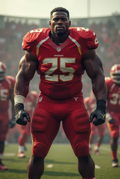 Tall, young, black, shaved offensive guard with a stocky, muscular build and a short, close-cropped black haircut. He wears a red football shirt.
