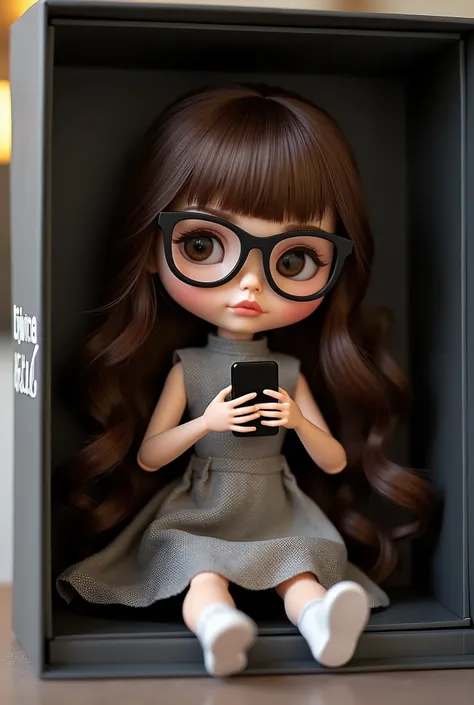 Poupée Blythe yeux marrons cheveux longs brune avec frange et lunette noire. Haute qualité. Téléphone portable à la main. Présenté dans sa boîte dans le magasin. Avec inscription poupée Kittana en relief blanc.