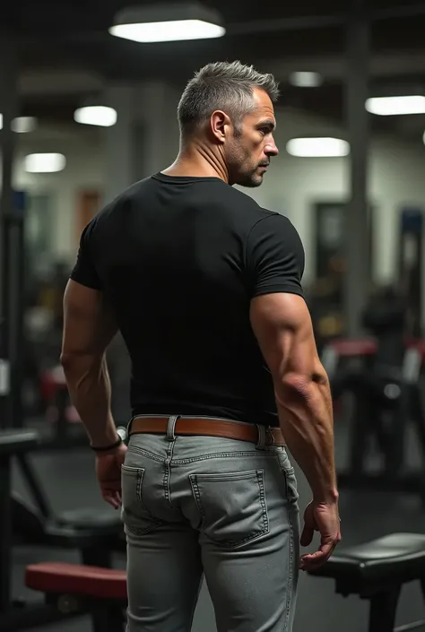 A sexy  Man in his 45s wearing jeans, muscular Hairy body, black shirt,  light gray jeans, brown belt, (((Big Bubble butt))) ,((( backside )))  de perfil, nalgon de perfIl, inclinado, en gym en banco inclinado de espaldas