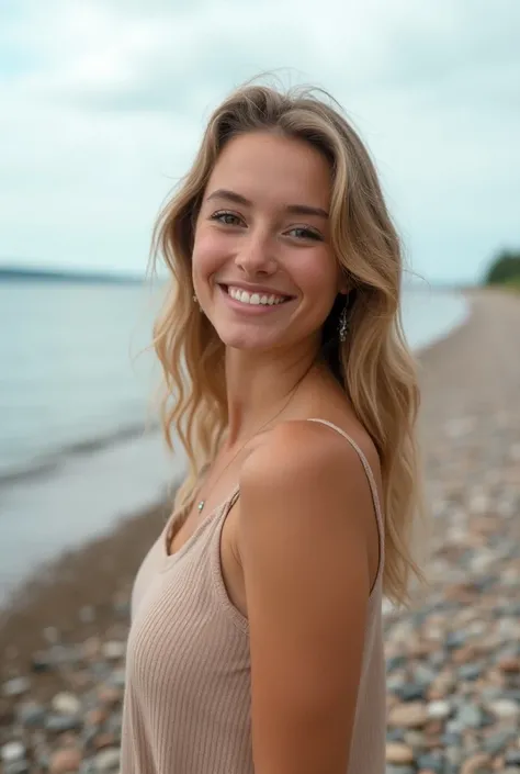 A cute young woman posing for a photo, typical of a MySpace post. She is smiling casually, with minimal makeup, on a pebble beach along Lake Superior on a summer day. The lighting is soft and natural