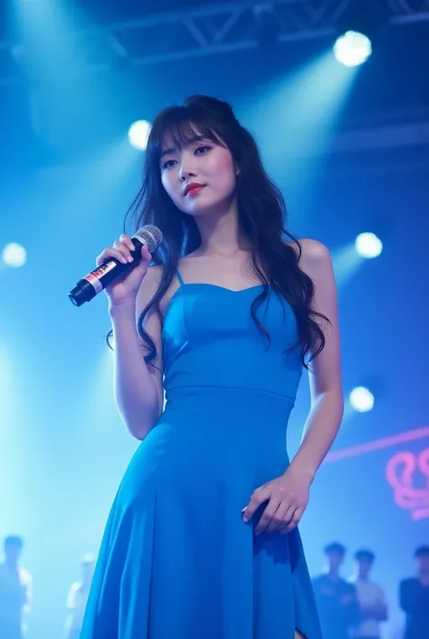 A Korean kpop girl in blue dress with bangs on stage with mic