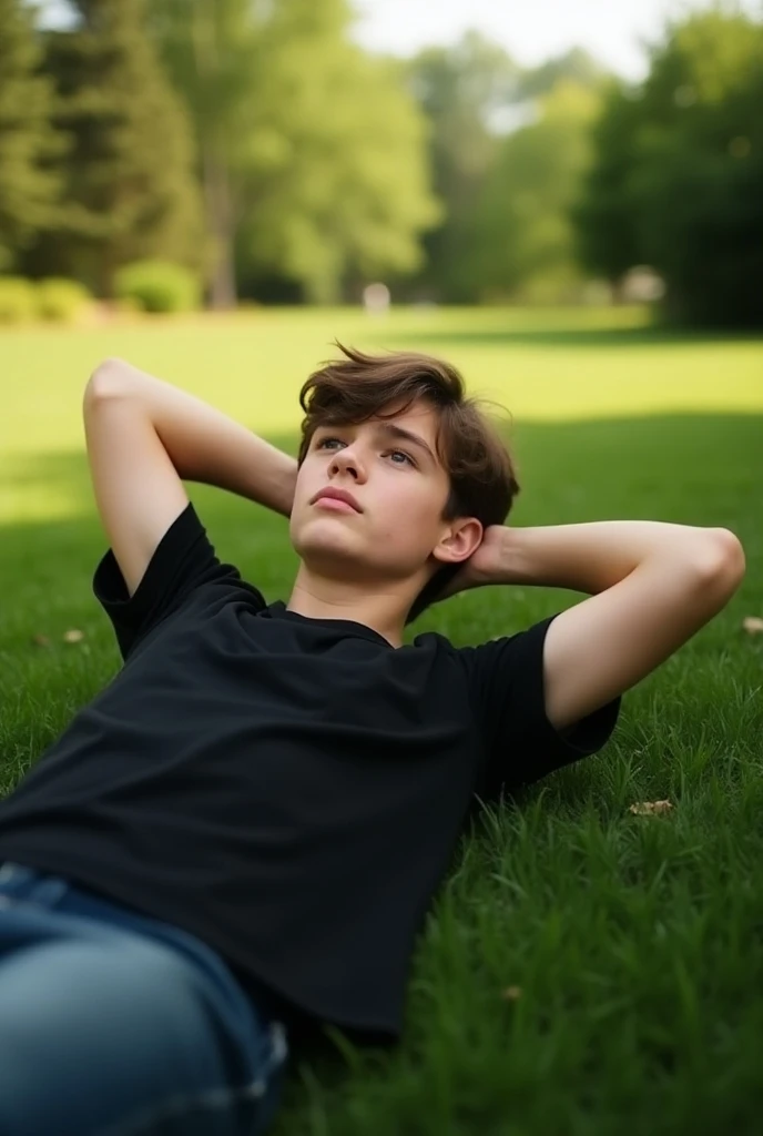 Young teenager lying on a lawn with his arms around the back of his head looking up thoughtfully wearing a black t-shirt 