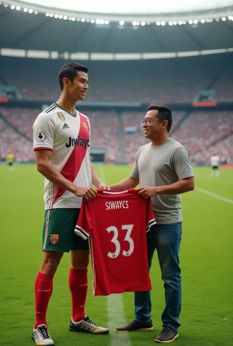 A photo of Cristiano Ronaldo, a world-class soccer player, standing next to a young Indonesian man wearing t shirt and jeans. They are holding a soccer shirt with the text "SIWAYCS" and the number "33". They are standing on a grass field. The background co...