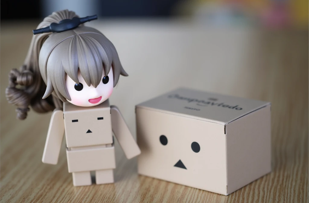 A woman wearing danbo costume, she has horsetail hair, brown hair, there is a box beside her