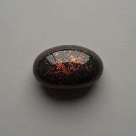 1 small black stone with orange sparkles