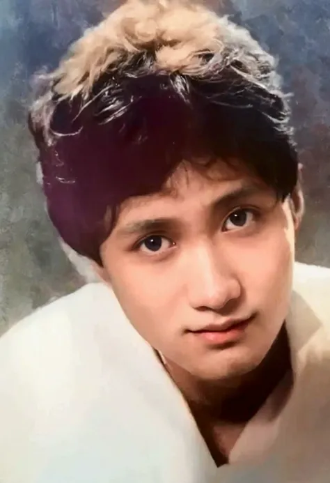 A portrait of a young Vietnamese man with short, slightly curly dark hair, looking upwards with a gentle expression. His face has soft features, with large, expressive eyes and a calm, thoughtful gaze. He is wearing a light-colored shirt, and the backgroun...