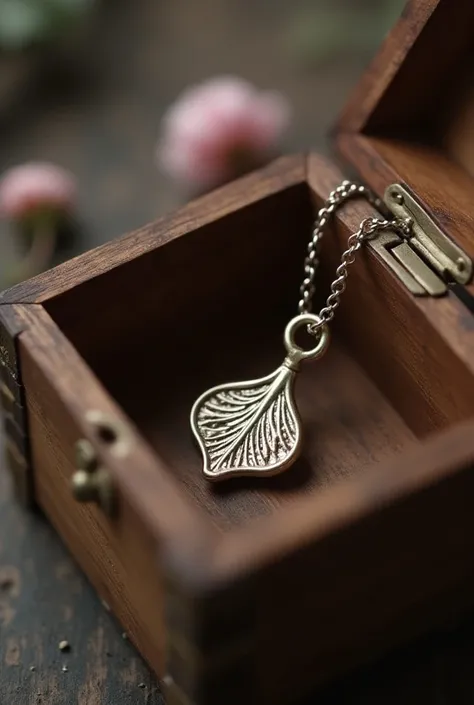 A necklace in the shape of a cherry petal key, dans un ecrin en bois un peu ancien 