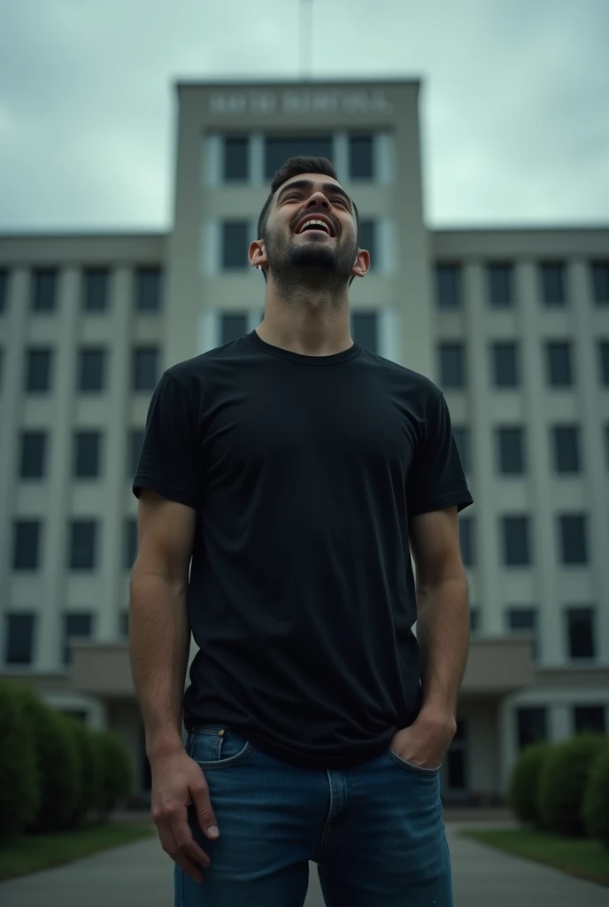 A 26-year-old man is crying in front of the hospital in front of the hospital, with tears streaming down his eyes, wearing a black shirt and blue jeans.