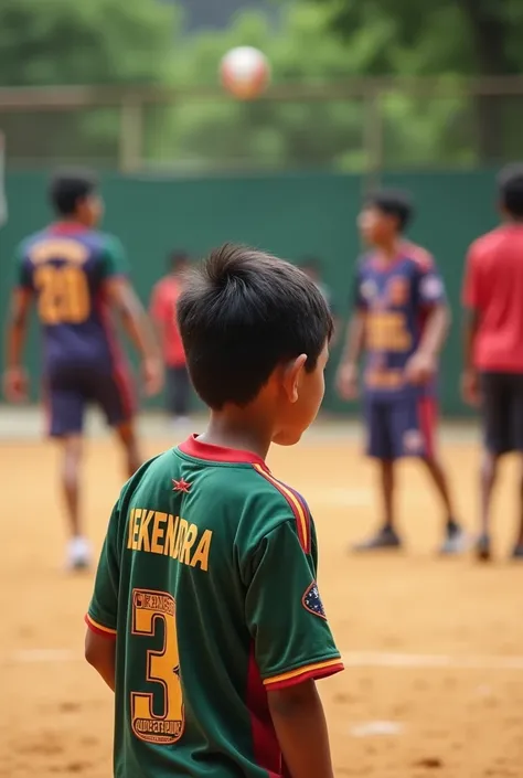 The boy watching in nepali volleyball game plag in ground.the boys wearing in nepali volleyboll  jersey  .the boy play in volleyball .the jersey name dekendra 3