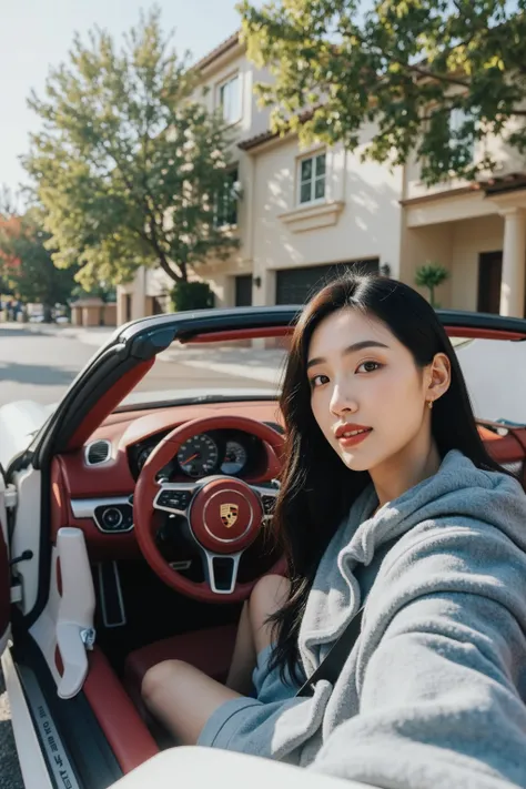 A 36-year-old female CEO takes a first-view selfie in the drivers seat of a white convertible Porsche 718 in front of a luxury villa in Los Angeles。Red interior 。See the steering wheel。Oriental woman with round face, full chest, long black hair 。Light make...