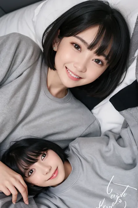 Girl in grey sweatshirts, black hair cut, Bob faces sideways on the bed in the white room and smiles