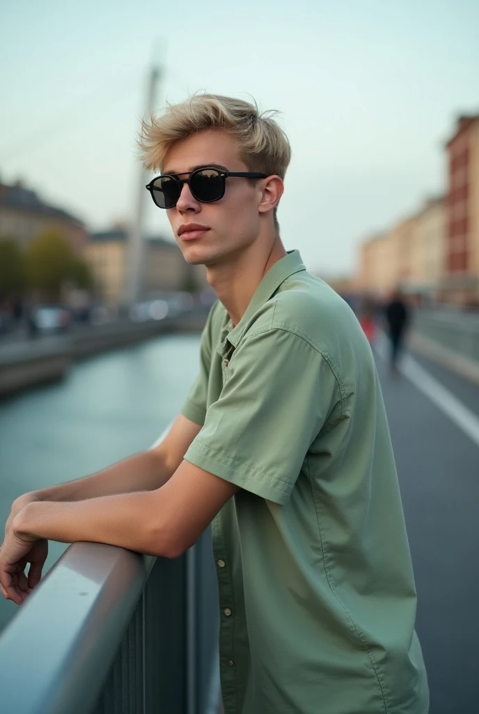 a guy in a light green shirt with blond hair and black sunglasses leaning with his hands, 
on a bridge and he is standing sideways 
in Stockholm