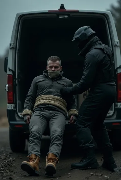 Sleeping nordic man wearing timberland boots is tighly bound with from his legs and hands and tape on his mouth laying down. Nordic capturer dressed black tactical boots has dragged him to back of the van. 