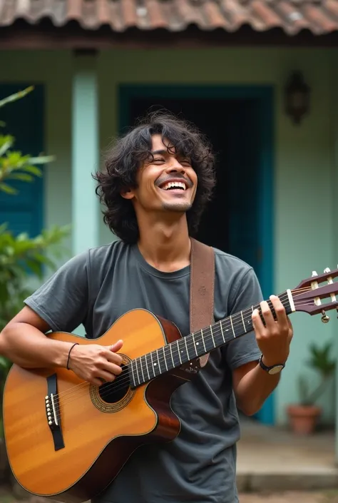 a 30 year old Indonesian man with curly shoulder-length hair wearing a modern t-shirt is playing his guitar in front of his house