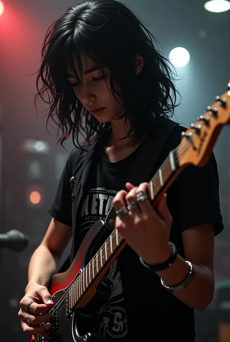 Long-haired boy who has rings and a guitar lenses a black vest music t-shirt and who has rings