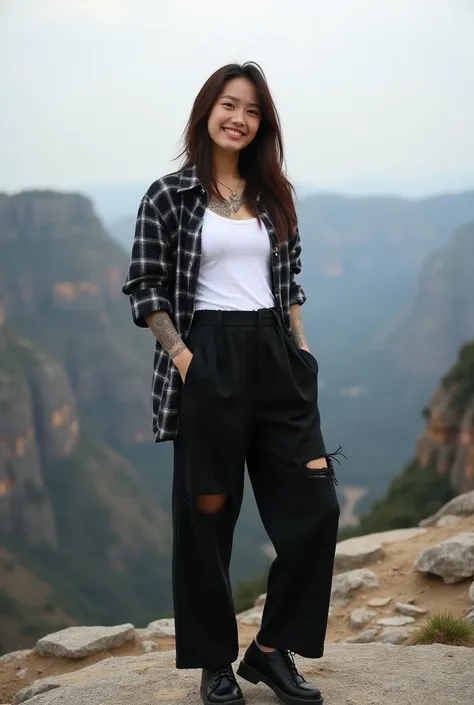 A beautifull tattooed girl from Korea, 27 years old, wearing a white t-shirt covered with a black checkered shirt and long black torn trousers, black shoes, standing proudly on a rocky cliff, facing the camera with a friendly smiling face, wide landscape.