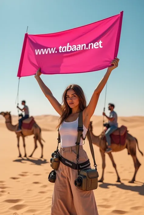 A picture of a real girl in the Tunisian desert with a pink banner in her hand with the word www.Tabaaan.net written on it, and they are holding a group of cameras and next to it is a camel.